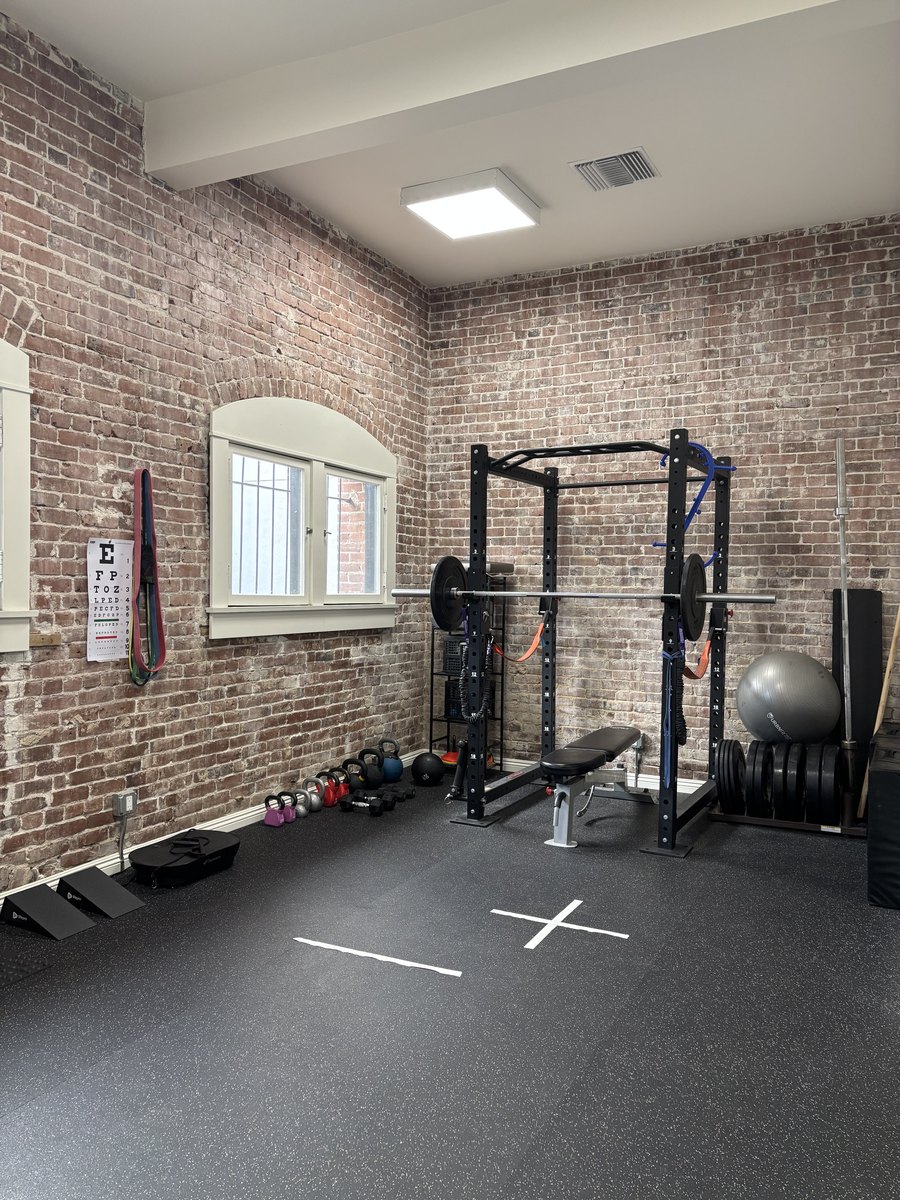 The training area at Movida, with a squat rack, kettlebells and open floor space for movement work
